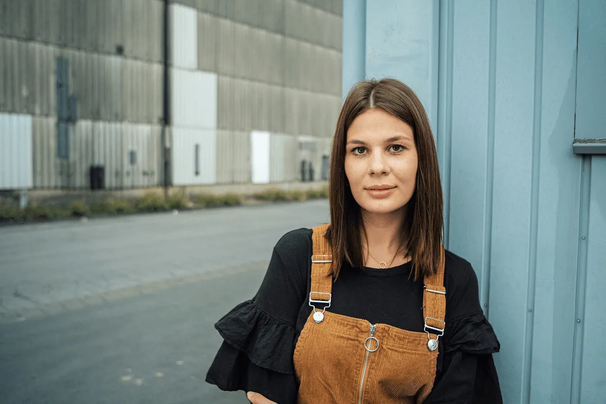 UP member in a rust apron against a blue wall